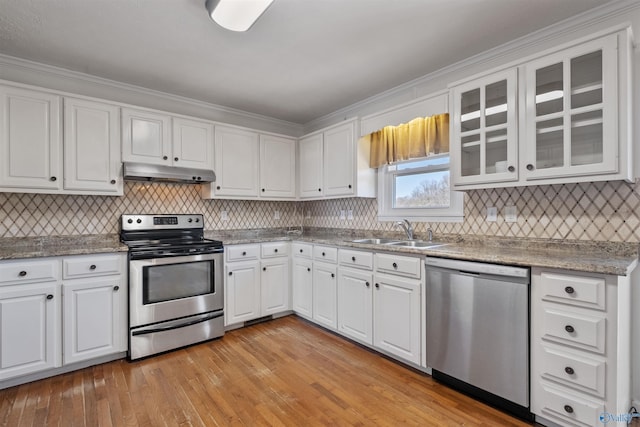 kitchen featuring a sink, stainless steel appliances, white cabinets, under cabinet range hood, and light wood-type flooring