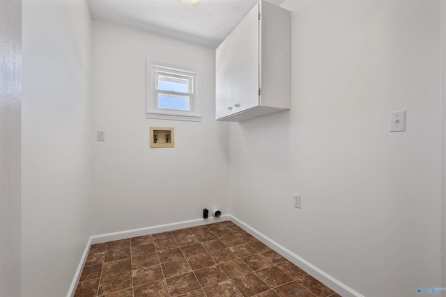 laundry area featuring washer hookup, cabinet space, and baseboards