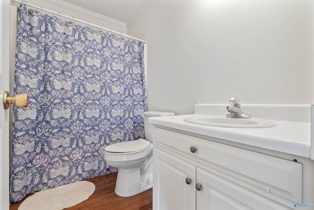 bathroom featuring a shower with curtain, toilet, ornamental molding, wood finished floors, and vanity