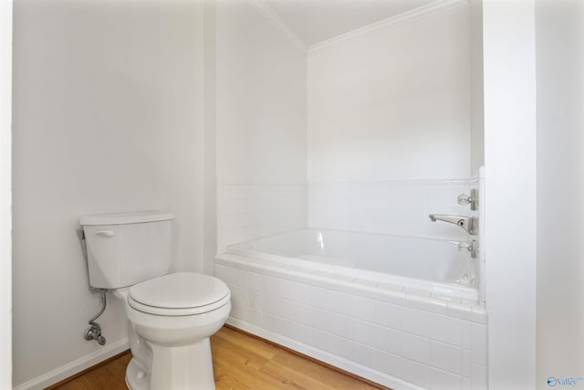 bathroom with wood finished floors, toilet, tiled tub, and ornamental molding