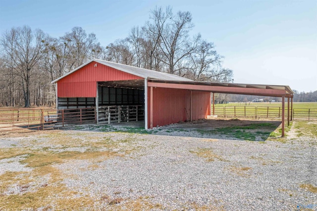 view of outdoor structure with a rural view, an outbuilding, a carport, and an exterior structure