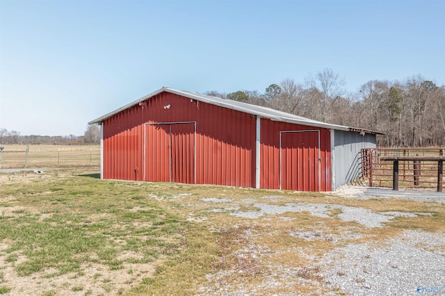 view of pole building with a lawn and fence