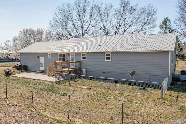 rear view of house featuring fence, a wooden deck, metal roof, crawl space, and a patio