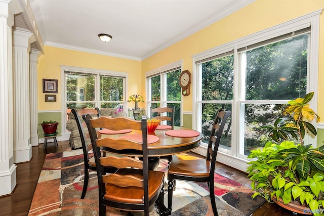 dining area featuring decorative columns, ornamental molding, and dark hardwood / wood-style floors