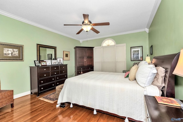 bedroom featuring crown molding, hardwood / wood-style floors, and ceiling fan