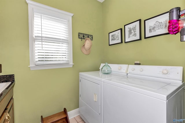 laundry room with cabinets, washing machine and dryer, and light tile patterned floors