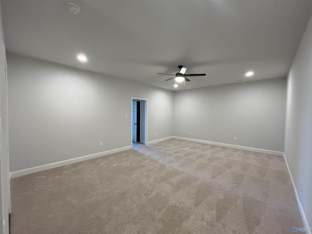 spare room with ceiling fan and light colored carpet