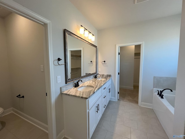 bathroom featuring tile patterned floors, a washtub, and vanity