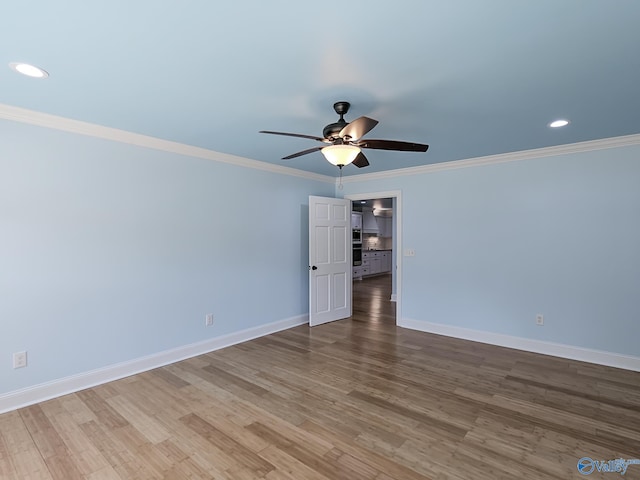 spare room with ornamental molding, hardwood / wood-style flooring, and ceiling fan