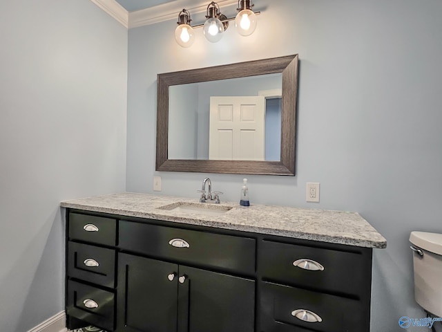 bathroom with vanity, crown molding, and toilet