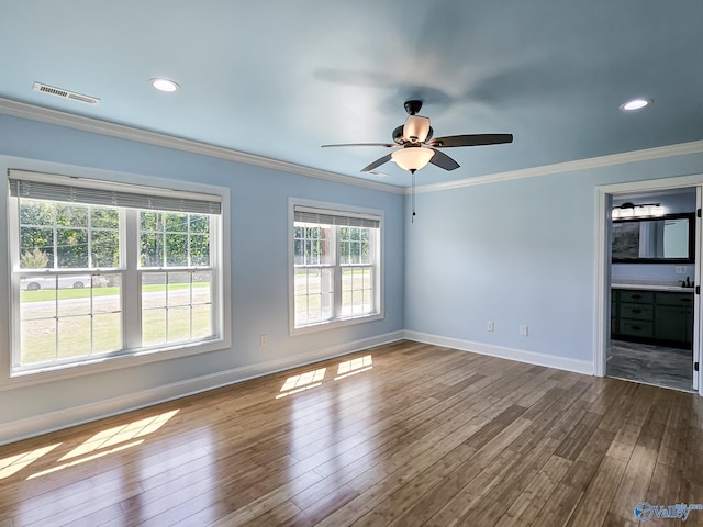 spare room featuring crown molding, ceiling fan, and wood-type flooring