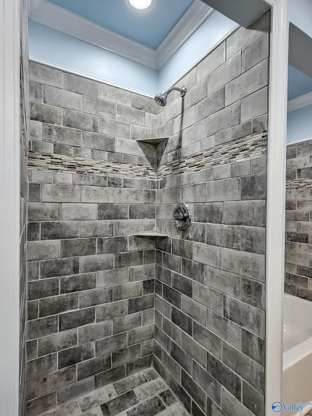 bathroom with ornamental molding and tiled shower