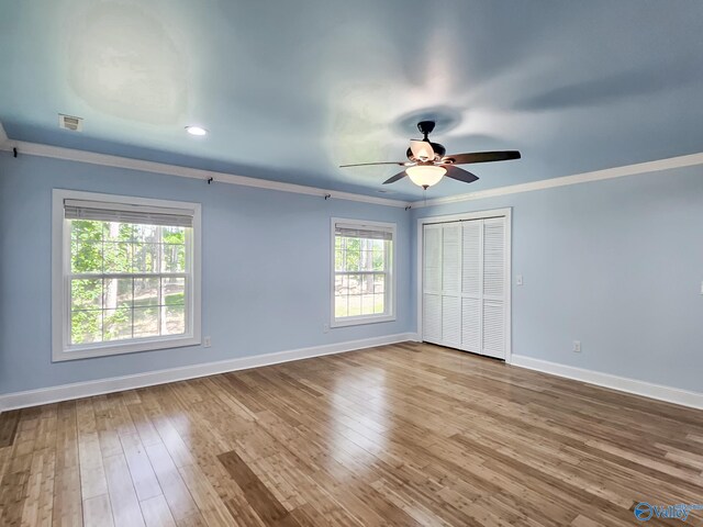 unfurnished room featuring ceiling fan, light wood-type flooring, and ornamental molding