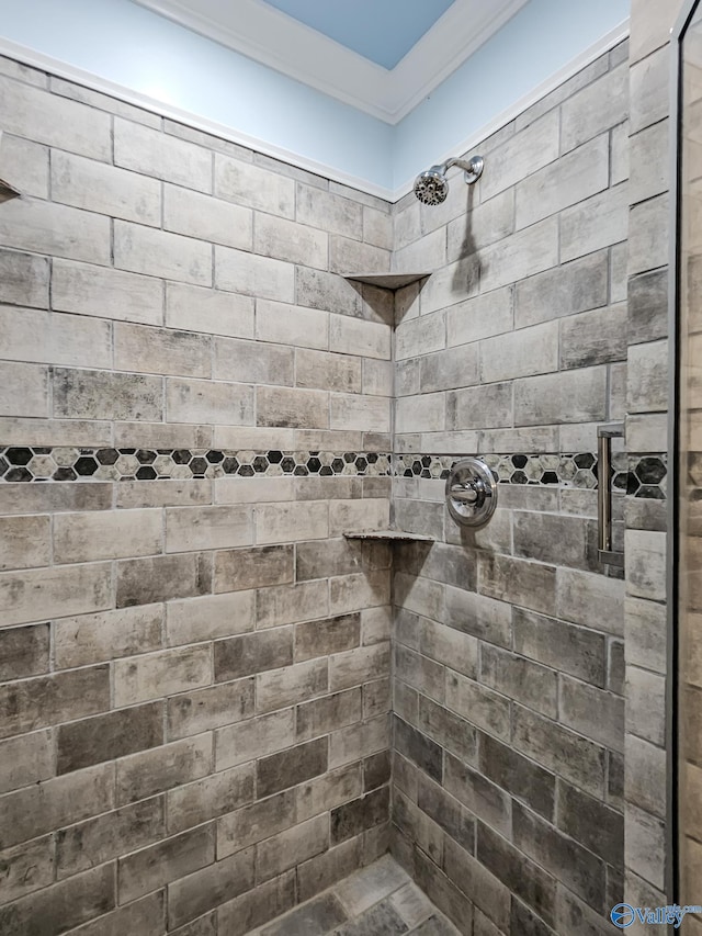 bathroom featuring crown molding and tiled shower