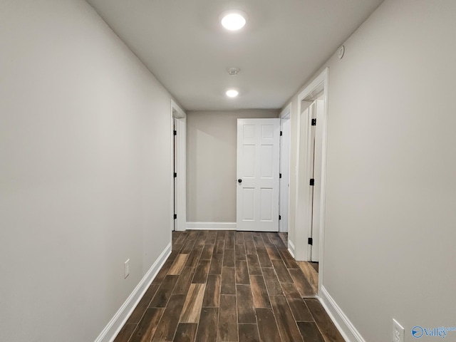 corridor with dark hardwood / wood-style flooring