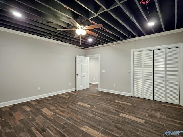 basement with dark hardwood / wood-style floors, crown molding, and ceiling fan