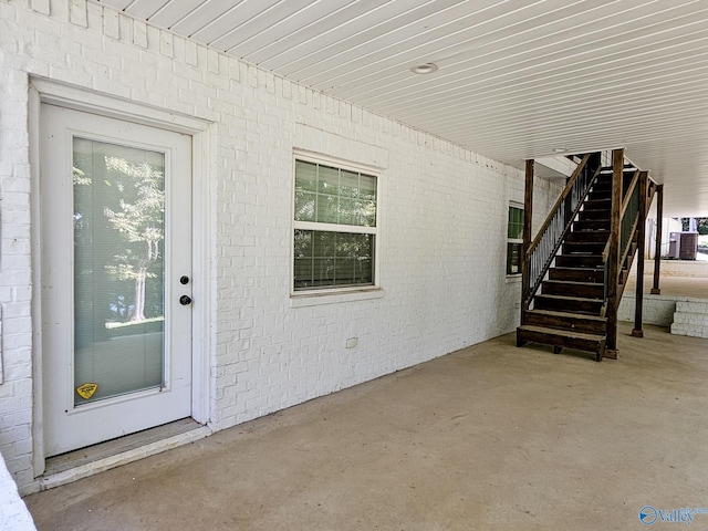 doorway to property featuring cooling unit and a patio