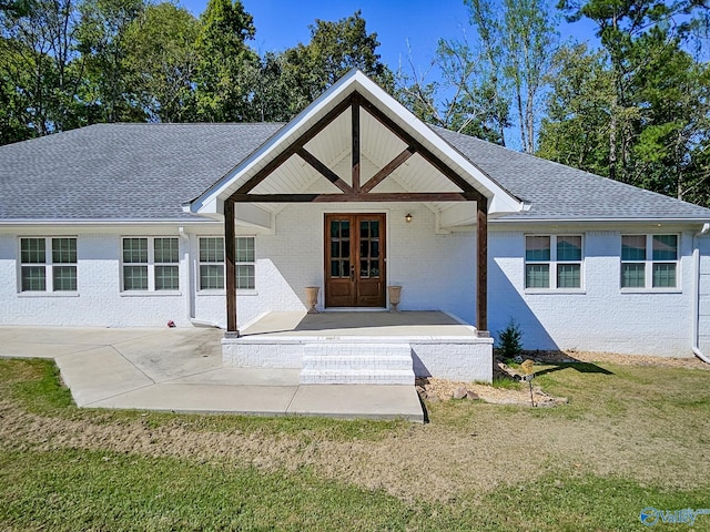 view of front facade with french doors, a patio area, and a front lawn