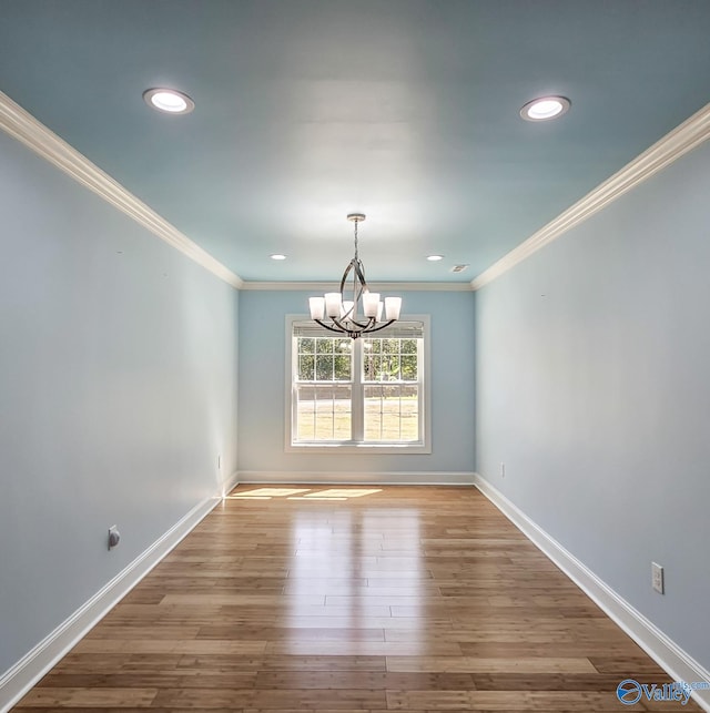 unfurnished dining area featuring a notable chandelier, crown molding, and wood-type flooring