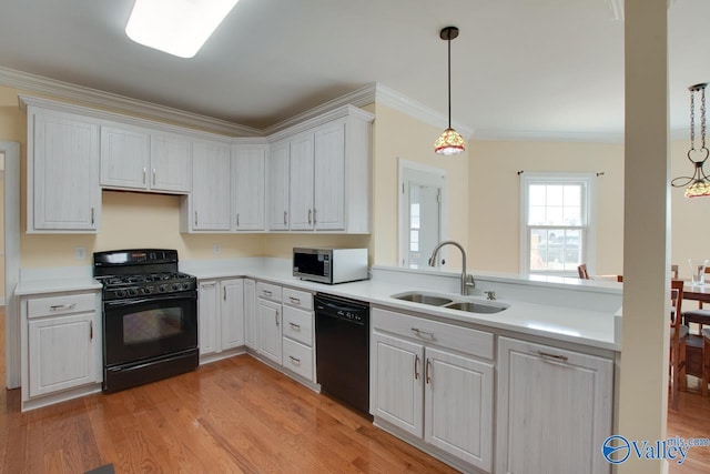 kitchen featuring ornamental molding, black appliances, light wood-style flooring, and a sink