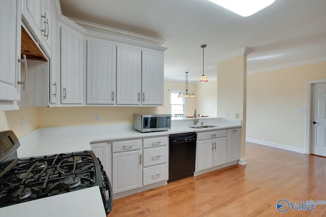 kitchen featuring black appliances, light countertops, light wood-style floors, and a sink