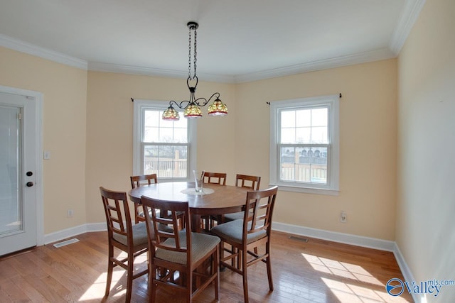 dining space with light wood finished floors, visible vents, a healthy amount of sunlight, and ornamental molding