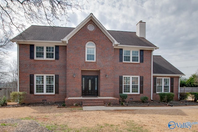 view of front of house featuring fence, brick siding, a chimney, and crawl space