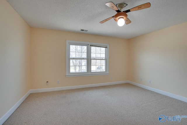 empty room featuring visible vents, baseboards, light colored carpet, and a textured ceiling