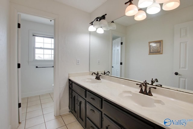 bathroom with tile patterned floors, double vanity, baseboards, and a sink