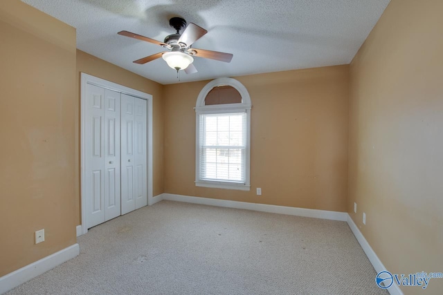 unfurnished bedroom featuring carpet flooring, baseboards, and a textured ceiling