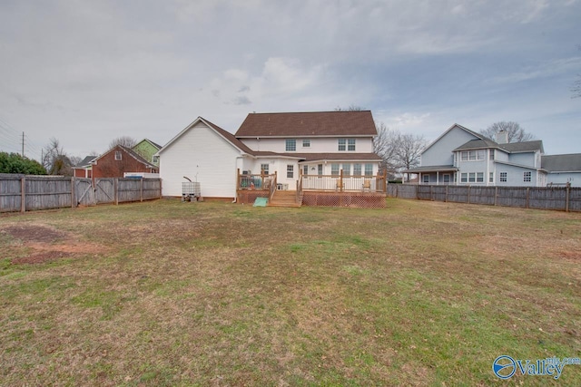 back of house with a yard, a wooden deck, and a fenced backyard