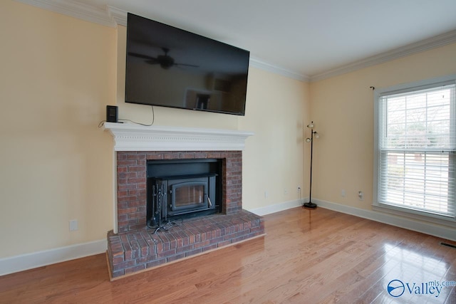 unfurnished living room featuring a brick fireplace, wood finished floors, baseboards, and ornamental molding