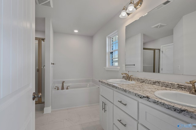 bathroom featuring vanity and independent shower and bath