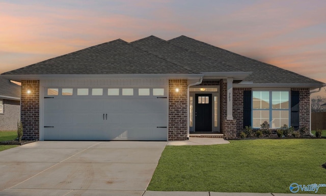 view of front of property featuring a garage and a yard