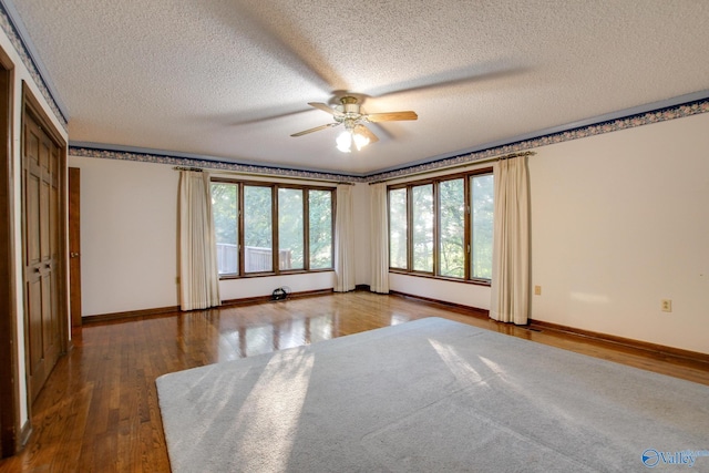 unfurnished bedroom with ceiling fan, dark hardwood / wood-style floors, and a textured ceiling