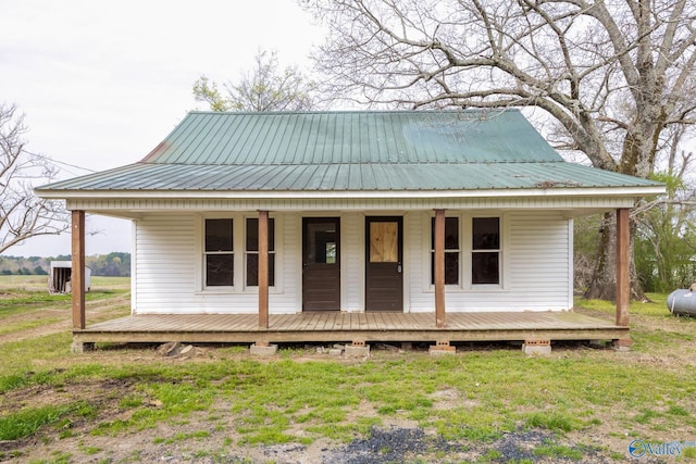 view of front facade featuring metal roof, a porch, and a front yard