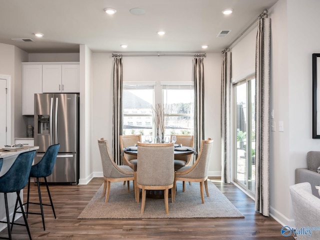 dining room featuring dark wood-style flooring, visible vents, and baseboards