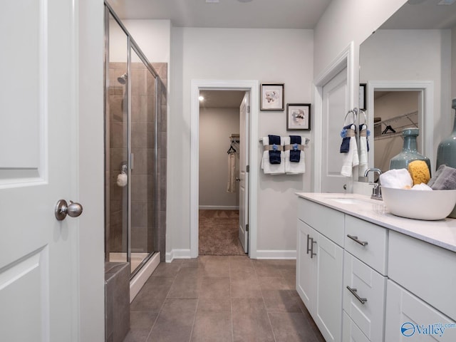 bathroom featuring a stall shower, vanity, and a spacious closet