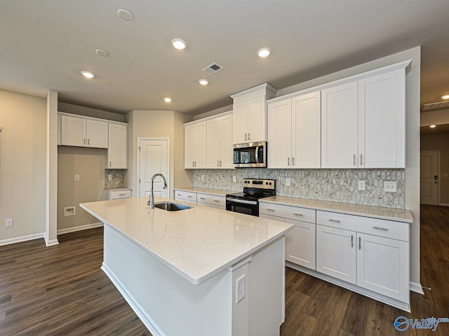 kitchen featuring electric range oven, stainless steel microwave, a sink, and white cabinets