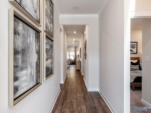 corridor with dark wood-style floors, ornamental molding, and baseboards