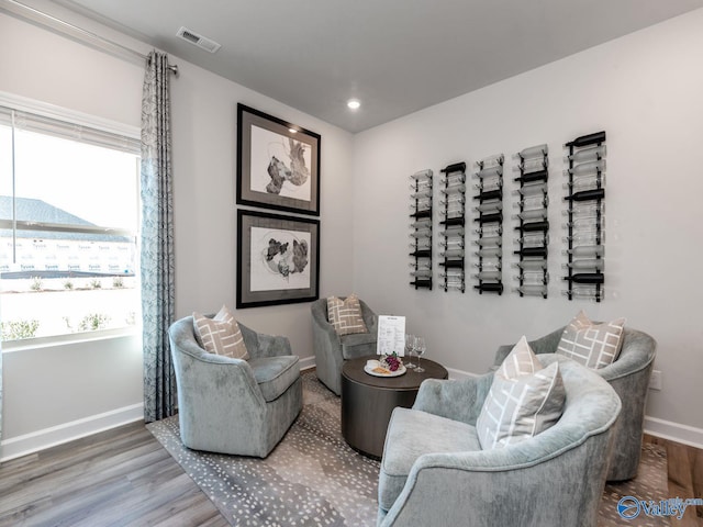 sitting room with visible vents, baseboards, recessed lighting, and wood finished floors