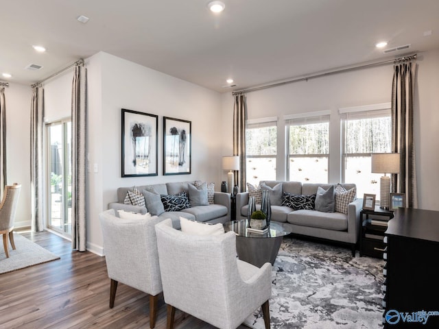 living area with recessed lighting, visible vents, and wood finished floors
