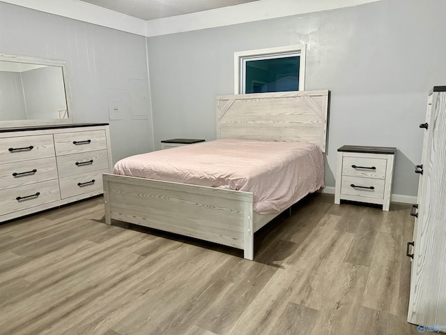 bedroom featuring baseboards and wood finished floors