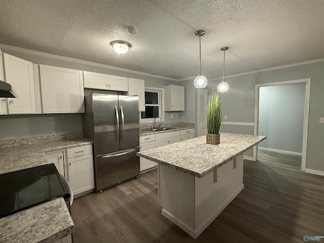 kitchen featuring a sink, a textured ceiling, dark wood finished floors, white cabinetry, and freestanding refrigerator