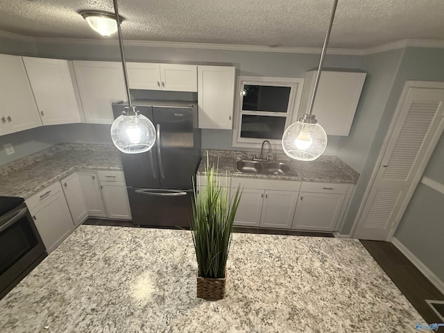 kitchen featuring range with electric cooktop, a sink, a textured ceiling, and freestanding refrigerator