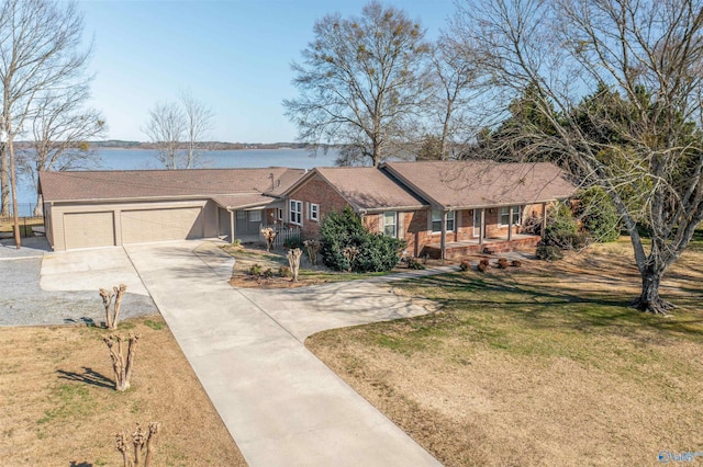 single story home with concrete driveway, a garage, brick siding, and a front lawn