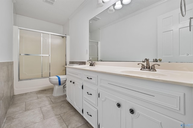 bathroom featuring tile patterned floors, double vanity, toilet, and a sink