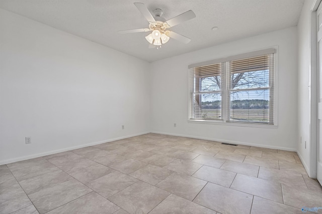 unfurnished room with light tile patterned floors, visible vents, baseboards, and ceiling fan