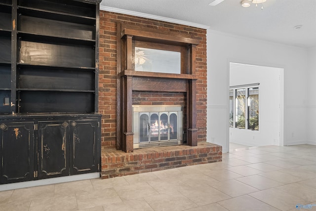 unfurnished living room featuring ceiling fan, ornamental molding, a fireplace, tile patterned floors, and a textured ceiling