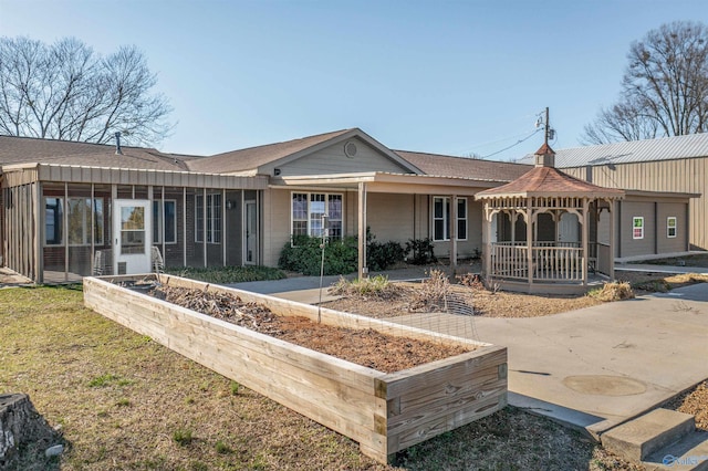 back of house with a gazebo and a sunroom